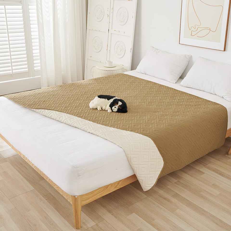 Sofa Cover tan side laid across a white bed