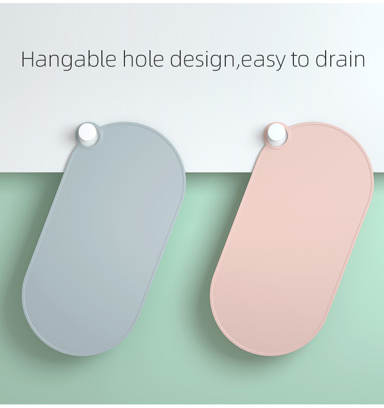 Gray and pink feeding mats hanging by the drain hole